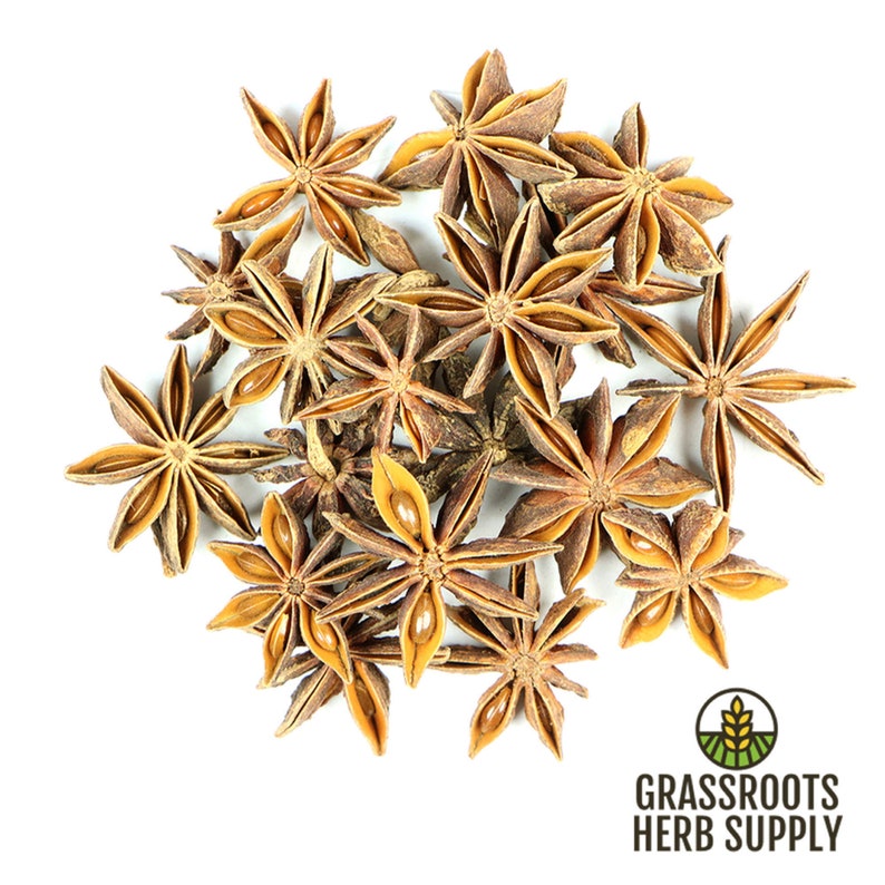 May include: A close-up of a pile of star anise pods, a popular spice used in Asian cuisine. The pods are brown and have a star shape with eight points. The pods are arranged in a random pattern on a white background.