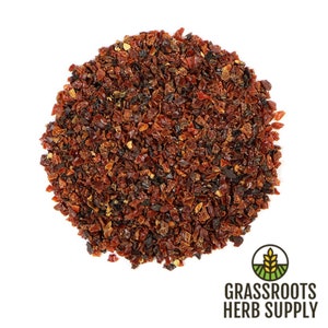 May include: A close-up of a pile of dried rose hips, a reddish-brown color, on a white background. The rose hips are a natural ingredient used in herbal teas and remedies.