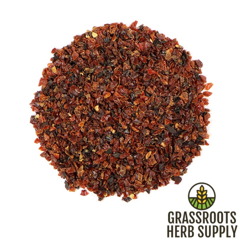 May include: A close-up of a pile of dried rose hips, a reddish-brown color, on a white background. The rose hips are a natural ingredient used in herbal teas and remedies.
