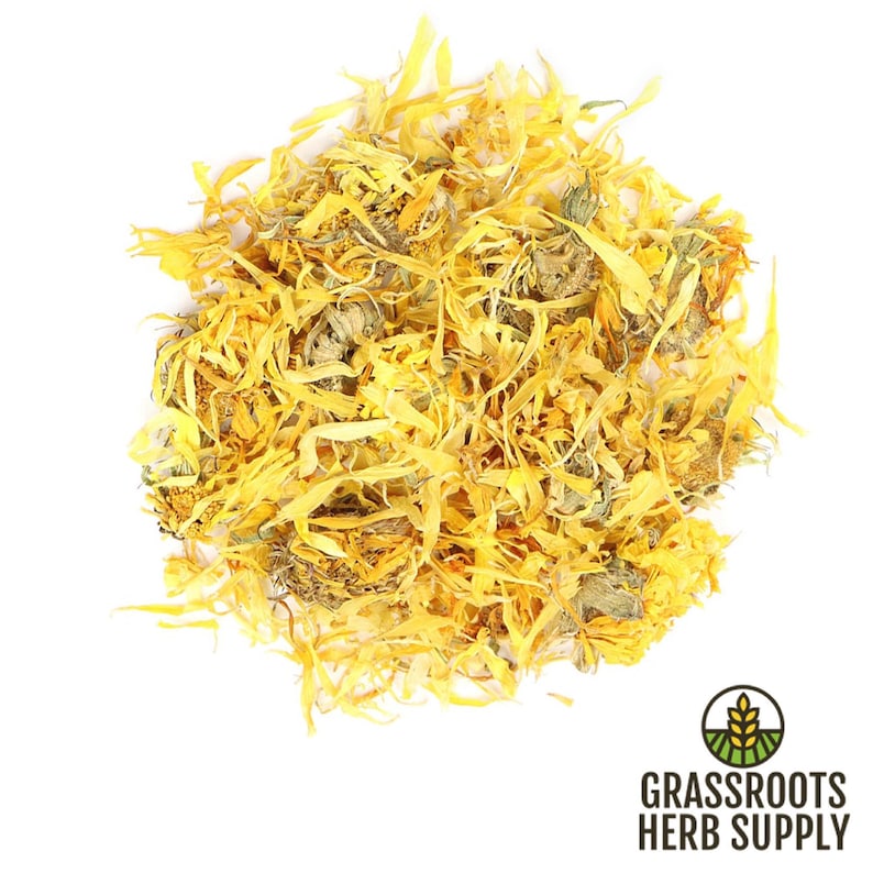May include: A close-up of a pile of dried calendula petals. The petals are a bright yellow color and have a slightly green tint. The petals are arranged in a loose pile and are ready to be used for crafting or herbal remedies.
