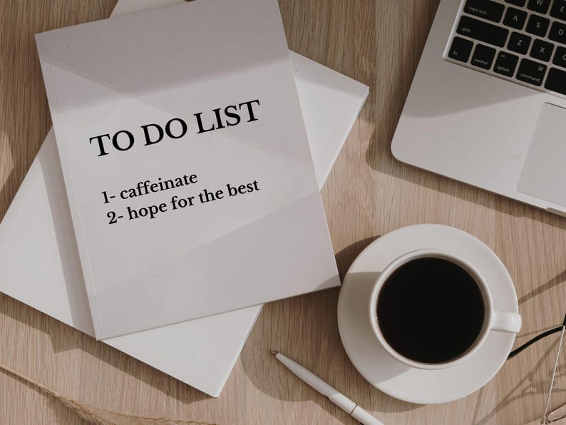 Pode incluir: Uma lista de tarefas brancas sobre uma mesa de madeira com uma x&iacute;cara de caf&eacute; e um laptop. A lista diz "TO DO LIST 1- caffeinate 2- hope for the best".