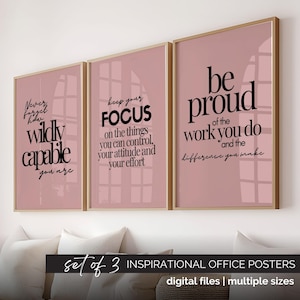 以下が含まれることがあります： 金色のフレームに入った、3枚のインスピレーションポスターのセット。各ポスターはピンク色の背景に黒い文字で書かれています。「あなたはどれほど能力があるかを決して忘れないでください」、「集中力を維持してください」、そして「あなたの仕事に誇りを持ってください」と書かれています。