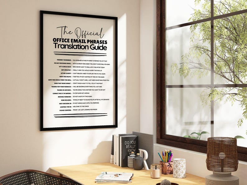 May include: A framed wall art print titled The Official Office Email Phrases Translation Guide, featuring a list of common professional email phrases and their sarcastic interpretations in black text on a white background, displayed in a black frame.