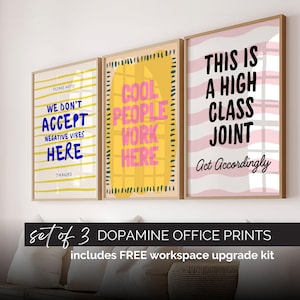 May include: A set of three framed wall art prints with light wood frames. The first print has yellow horizontal lines and blue text reading WE DON'T ACCEPT NEGATIVE VIBES HERE. The second has a yellow shape and pink text reading COOL PEOPLE WORK HERE. The third has pink wavy lines and black text reading THIS IS A HIGH CLASS JOINT Act Accordingly.
