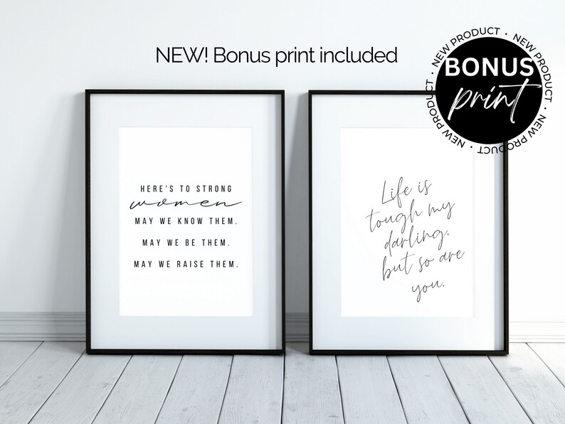 May include: Two black framed prints with white backgrounds and black text. The left print reads "Here's to strong women. May we know them. May we be them. May we raise them." The right print reads "Life is tough my darling, but so are you."