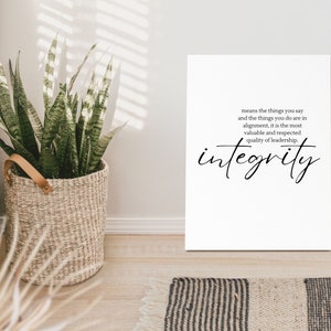 以下が含まれることがあります： 白いキャンバスに黒い文字で「means the things you say and the things you do are in alignment, it is the most valuable and respected quality of leadership. integrity」と書かれたプリント