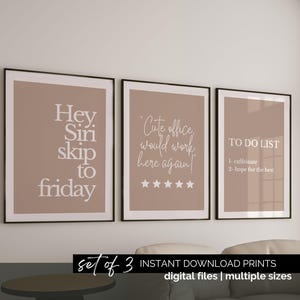 May include: Set of three framed prints with inspirational quotes. The prints feature phrases like "Hey Siri skip to Friday" and "Cute office would work here again!" in white text on a tan background. The frames are black.