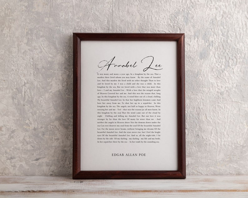 Pu&ograve; includere: Una stampa incorniciata con una cornice in legno marrone e uno sfondo bianco. La stampa presenta una poesia intitolata "Annabel Lee" di Edgar Allan Poe. La poesia &egrave; scritta in un carattere classico ed &egrave; centrata sulla pagina.
