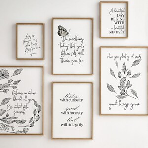 Może przedstawiać: Kolekcja oprawionych wydruk&oacute;w artystycznych z inspirującymi cytatami i ilustracjami botanicznymi. Wydruki mają złote ramy i czarny tekst na białym tle. Jeden wydruk przedstawia motyla, a inny m&oacute;wi: &bdquo;Piękny dzień zaczyna się od pięknego nastawienia&rdquo;.