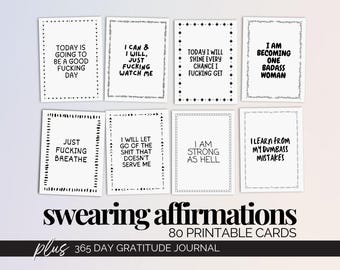 May include: A collection of eight white affirmation cards with black text, each framed with decorative borders. The cards feature empowering phrases like "Today is going to be a good fucking day" and "I am becoming one badass woman." The image also includes the text "swearing affirmations."