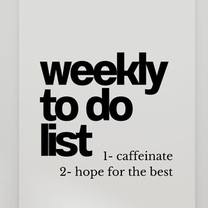 May include: A white poster with the words "weekly to do list" in bold black font. Below, the list includes "1- caffeinate" and "2- hope for the best." The poster is held by two wooden clothes pegs.