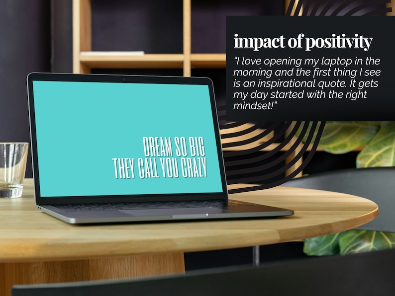 May include: A laptop computer with a blue screen displaying the text "DREAM SO BIG THEY CALL YOU CRAZY". The laptop is on a wooden table in a modern office setting. The text "impact of positivity" is visible in the upper right corner of the image.