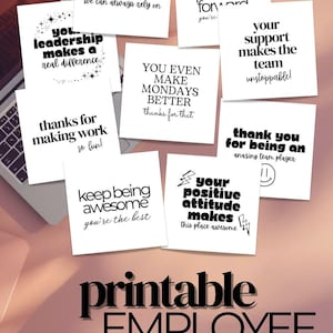 May include: A collection of white employee appreciation cards with black text, featuring phrases like "Thank you for being an amazing team player" and "Your support makes the team unstoppable!" The cards are arranged on a desk with a laptop.