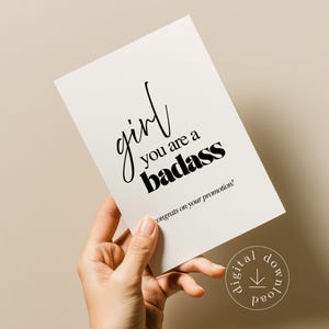 Könnte beinhalten: Eine weiße Karte mit dem Text "girl you are a badass" in schwarzer Schrift und fetter Schrift. Die Karte enthält auch den Text "congrats on your promotion!" in einer kleineren Schriftart. Ein digitales Download-Symbol befindet sich in der unteren rechten Ecke.
