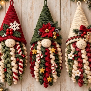 May include: Three crocheted gnome ornaments with pointed hats in red, green, and cream. Each gnome features a round nose and a long, curly beard decorated with festive elements like candy canes, stars, flowers, berries, and a gingerbread man.