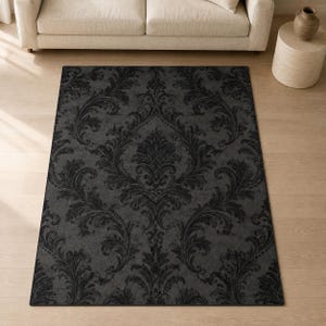 May include: A rectangular area rug featuring a dark charcoal gray background with a repeating black damask pattern. The intricate, symmetrical floral and leaf motifs are arranged in a vertical orientation across the entire surface of the rug.