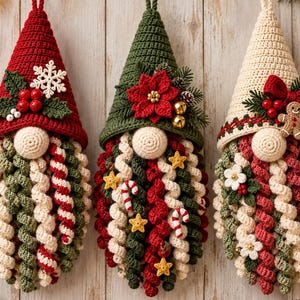 Può includere: Tre ornamenti a forma di gnomo all'uncinetto con cappelli a punta rossi, verdi e color crema. Il cappello rosso presenta un fiocco di neve bianco e agrifoglio. Il cappello verde ha una stella di Natale rossa. Il cappello crema include un omino di pan di zenzero.