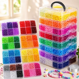 May include: A multi-tiered clear plastic storage container with a black handle, filled with assorted colorful pony beads. Several individual square organizers are arranged nearby, each containing six compartments of sorted beads in various colors.