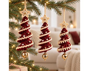 May include: Three hanging Christmas tree ornaments made of dark red crocheted yarn with cream-colored spiral trim. Each ornament features a cream crocheted star at the top, small silver and gold beads throughout the body, and a gold jingle bell at the base.