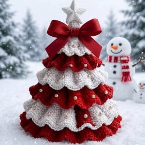 May include: A tiered crochet Christmas tree decoration featuring alternating red and white ruffled layers adorned with small white pearls. The tree is topped with a white crocheted star and a large red satin ribbon bow tied at the peak.