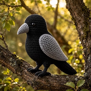 May include: A handcrafted crochet crow toy featuring a solid black body, a textured grey beak, and light grey wings. The bird has a small black bead eye and is constructed with visible yarn stitches, showcasing a detailed and rounded avian form.