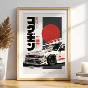 May include: A framed wall art print featuring a white drift car with red accents, a large red circle, and bold black Japanese text. The composition includes a vertical dark gray panel and smaller red text blocks, showcasing a dynamic automotive design.
