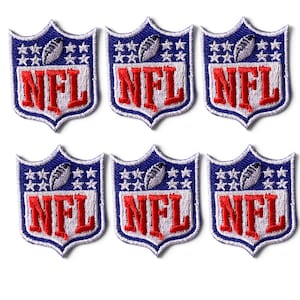 May include: A pack of 6 embroidered NFL shield patches, each measuring 1.25x1.75 inches. The shield features a blue top section with white stars and a football, and a white bottom section with the red NFL logo text. The edges are white.