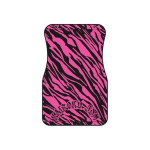 Könnte beinhalten: Eine rechteckige Autofußmatte mit einem leuchtend pinkfarbenen und schwarzen Tigerstreifenmuster. Im unteren Bereich der Matte ist der Schriftzug "BIROKU JDM" in einer stilisierten, dunklen, gotisch angehauchten Schriftart zu sehen.