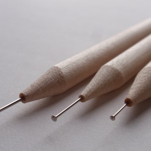 May include: Three wooden tools with metal tips, used for crafting and creating detailed designs.