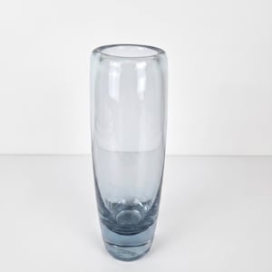 Può includere: Un vaso cilindrico alto in vetro con una finitura liscia e trasparente. La base del vaso presenta una tonalità blu più profonda e satura che sfuma gradualmente verso una tonalità più chiara e traslucida in corrispondenza dell'apertura.