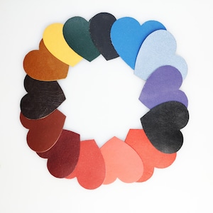 May include: A circle of 14 leather heart shapes in various colours, including red, orange, yellow, green, blue, purple, and brown.
