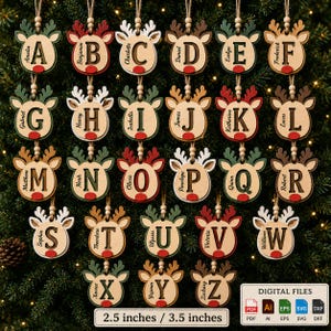 May include: A collection of twenty-six wooden reindeer-shaped Christmas ornaments, each featuring a unique letter of the alphabet and a name. The ornaments have red noses, antlers, and twine hangers. Text indicates 2.5 inches / 3.5 inches.