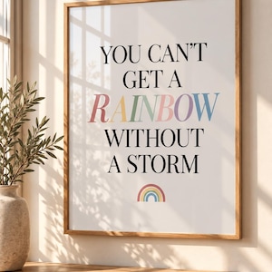 May include: A framed wall art print featuring the black text "YOU CAN'T GET A RAINBOW WITHOUT A STORM" with the word "RAINBOW" written in multicoloured pastel letters. A small, simple rainbow icon is centred at the bottom of the white background.