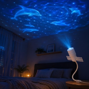 May include: A white cylindrical projector lamp with a flexible neck and small side panels, emitting a bright blue light that casts a dynamic projection of swimming dolphins, water ripples, and small stars onto the ceiling of a darkened bedroom.