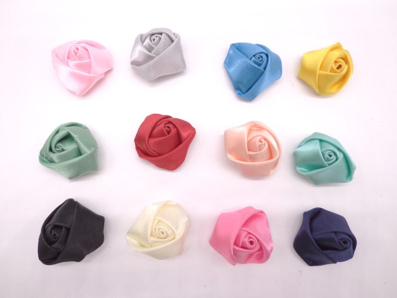 May include: Twelve small fabric rose embellishments in various colors, including pink, blue, green, red, cream, and black.