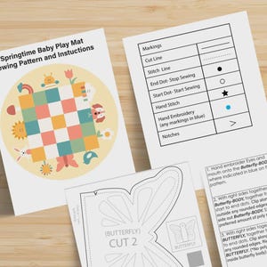 May include: A sewing pattern and instruction set for a Springtime Baby Play Mat. The documents include a title page with a colorful checkered mat illustration, a legend defining sewing markings, and detailed steps for creating a butterfly shape.