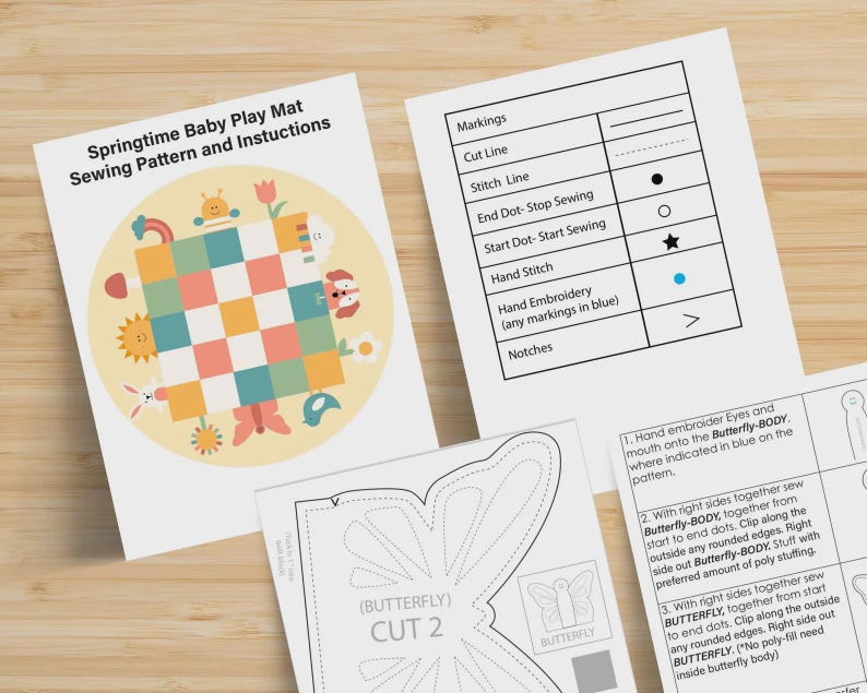 May include: A sewing pattern and instruction set for a Springtime Baby Play Mat. The documents include a title page with a colorful checkered mat illustration, a legend defining sewing markings, and detailed steps for creating a butterfly shape.