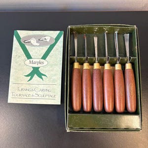 May include: A set of six Marples wood turning and carving chisels with brown wooden handles and metal ferrules, housed in a green cardboard box. An accompanying instruction booklet features the text Marples Turning & Carving.