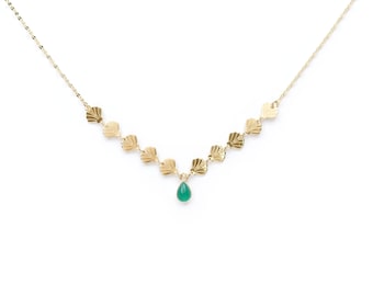 May include: A gold necklace with a teardrop-shaped green gemstone pendant and a series of small, scallop-shaped charms.