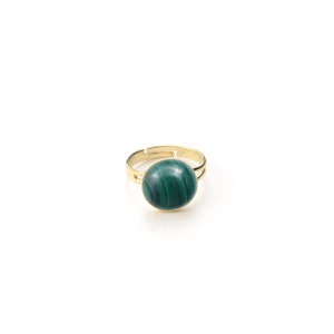 May include: A gold-toned adjustable ring featuring a large, round, polished malachite stone. The stone displays a rich, dark green color with swirling patterns. The ring's band is simple and elegant, with a delicate design around the stone's setting.