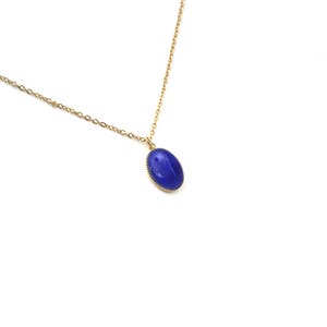 May include: A gold chain necklace with a blue oval pendant.