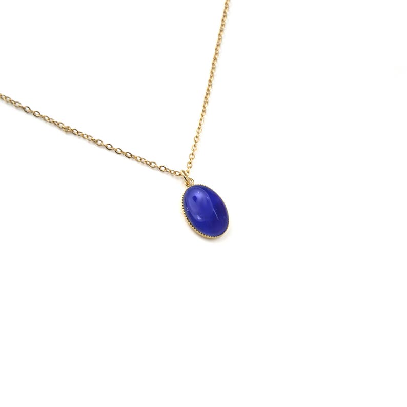 May include: A gold chain necklace with a blue oval pendant.