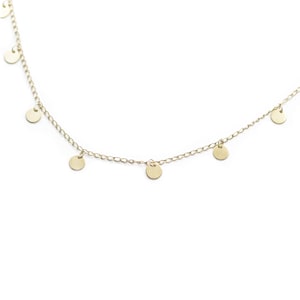 May include: A gold chain necklace with small, round, dangling charms.