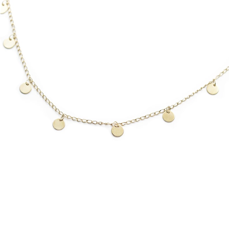 May include: A gold chain necklace with small, round, dangling charms.
