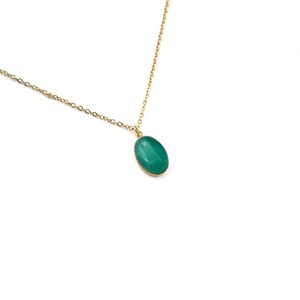 May include: A gold chain necklace with a green oval pendant.