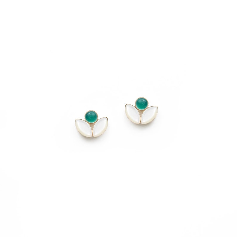 May include: A pair of gold earrings with white and green enamel. Each earring features a green oval-shaped stone surrounded by two white petals.
