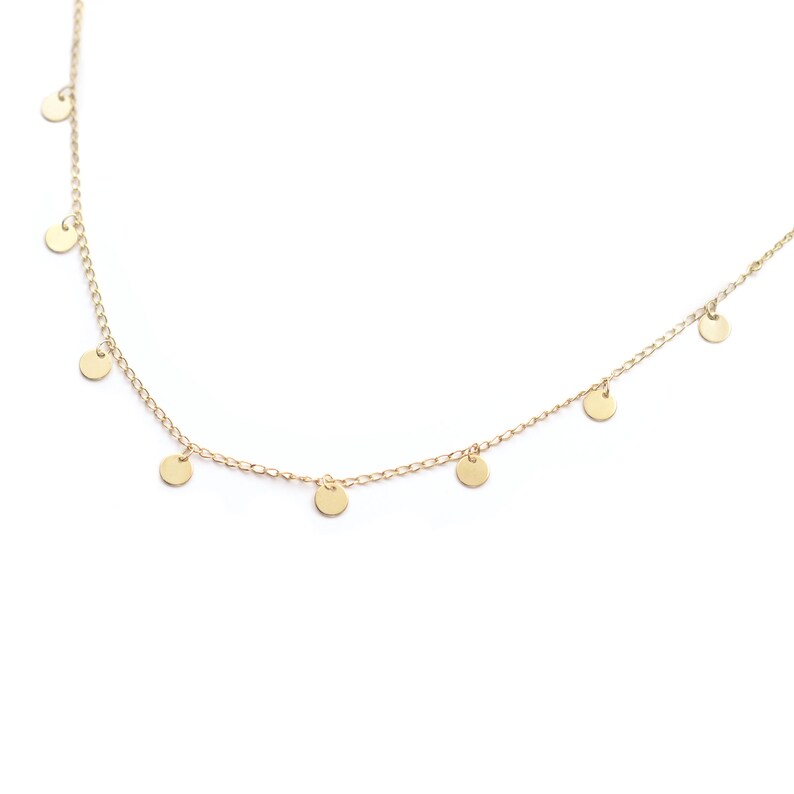 May include: A gold chain necklace with small, round, dangling charms.