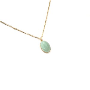 May include: A gold chain necklace with a light green oval pendant.