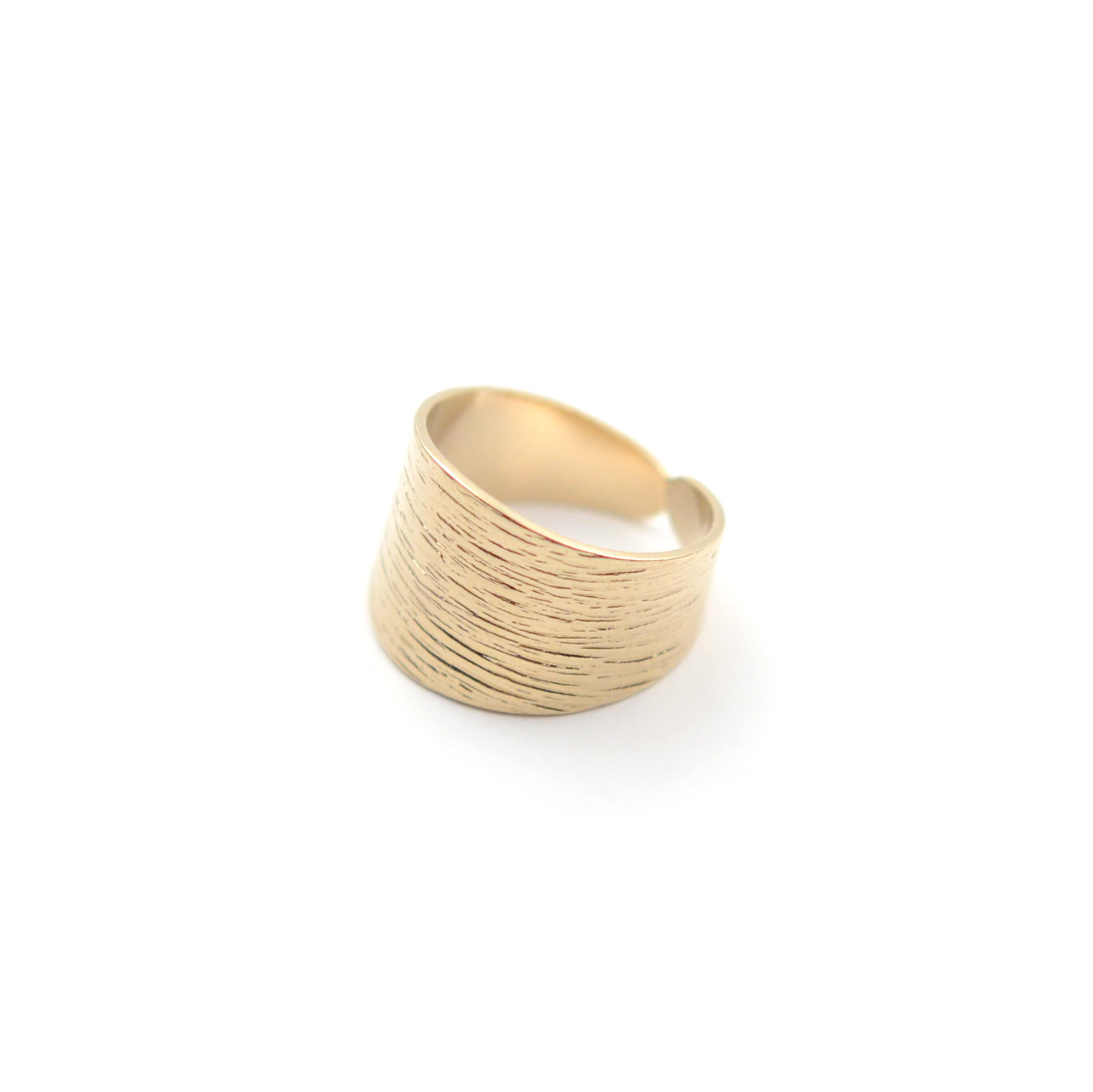 May include: A gold-toned ring with a textured, ridged design. The ring is wide and has a slightly curved shape.
