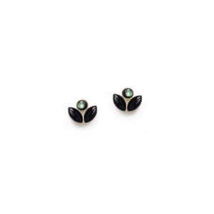 May include: A pair of black and green flower-shaped earrings with a green gemstone in the centre.